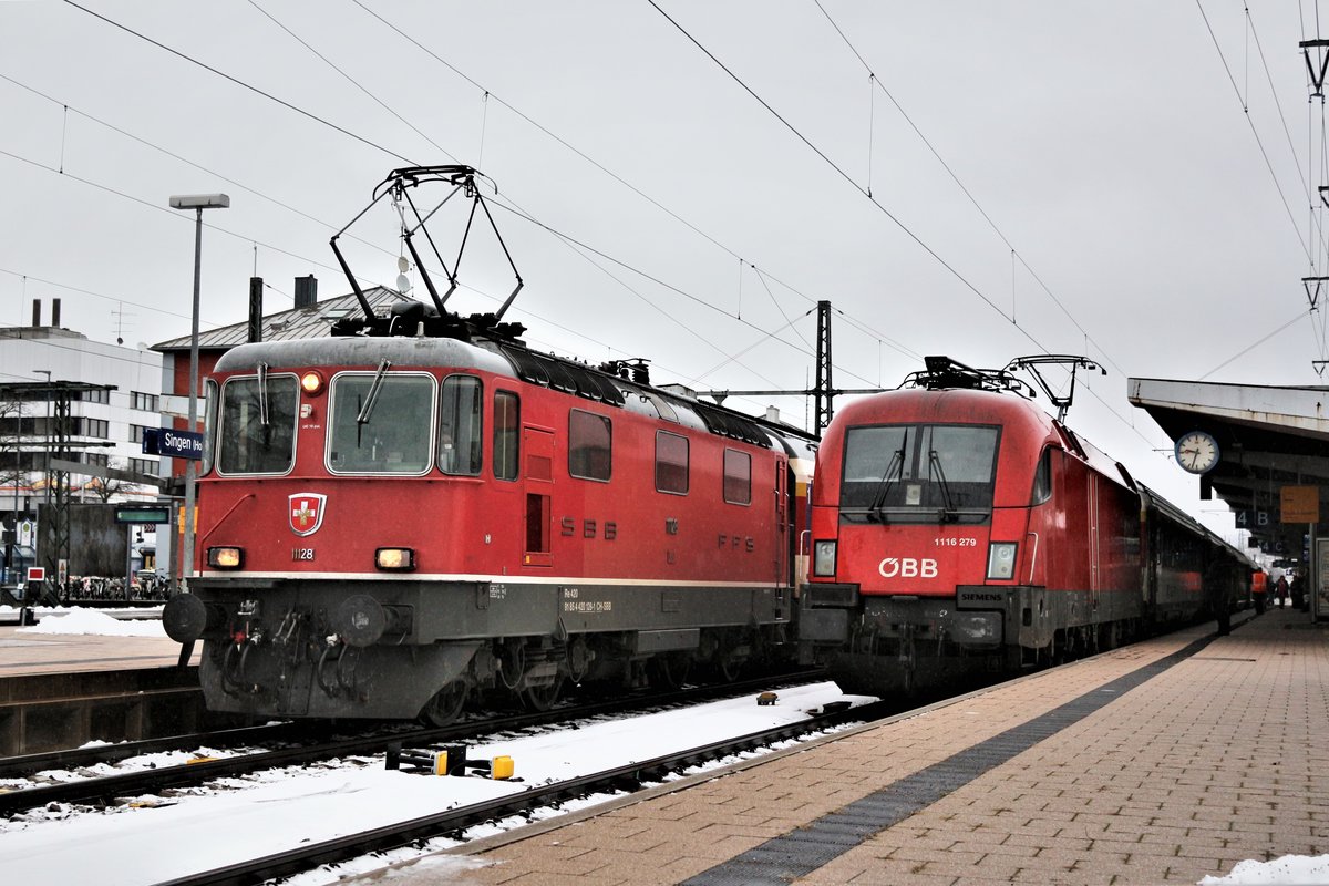 SBB/ÖBB Lokwechsel: Nachdem die SBB Re 421 den IC aus Zürich HB brachte, wurde die SBB Re 421 am Zugschluss abgekoppelt. Währenddem wurde die ÖBB 1116 279 vor dem IC gespannt.
Nebenan, auf Gleis 3 hat die SBB Re 4/4 II Nr. 11128 ab Singen (Htw.) den IC aus Stuttgart Hbf übernommen, und befindet sich im Bild auf der Abfahrt nach Zürich. 30. Dezember 2017