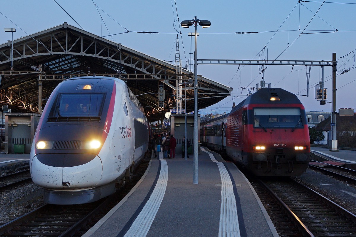 SBB/TGV: Abendstimmung im Bahnhof Lausanne am 23. Februar 2014. Doppeltraktion TGV Lyria mit TGV 9272  und SBB Re 460 115-9 mit IR 1434 Kurz vor der Abfahrt in Richtung Paris-Gare de Lyon und Genève.
Foto: Walter Ruetsch
