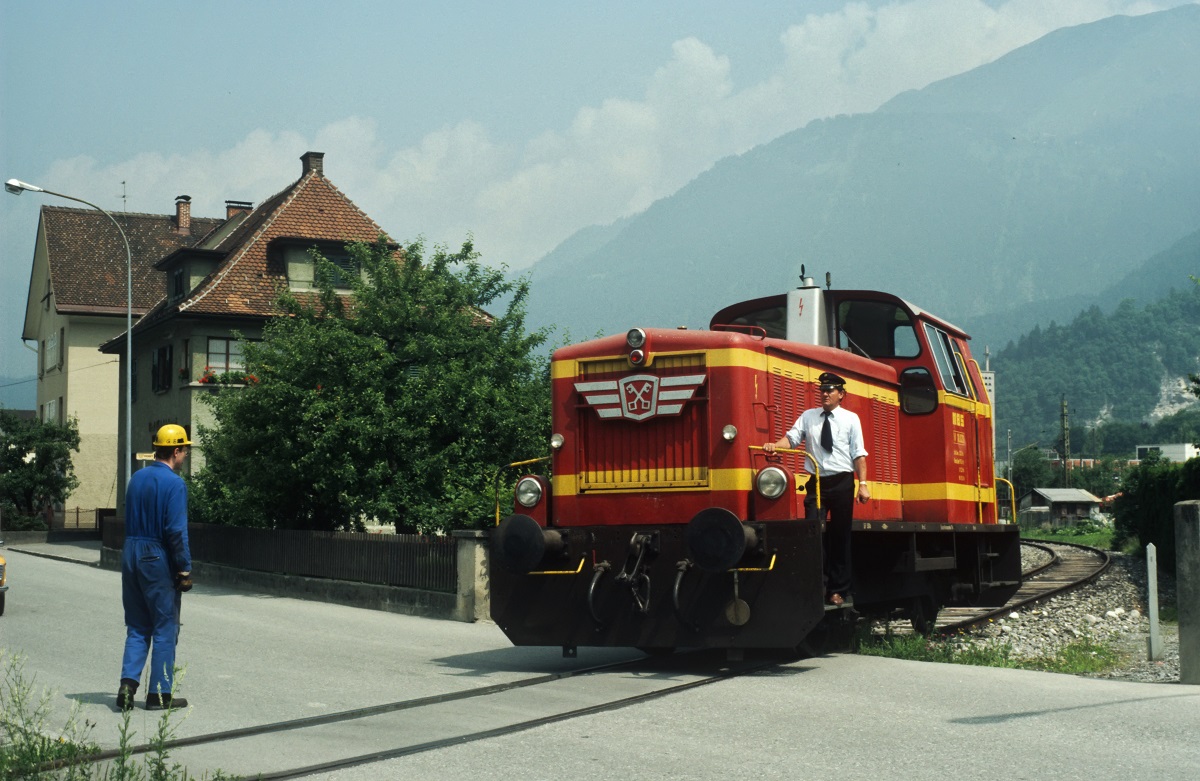 Scan vom Dia: Die MBS V10.012 überquert im Rahmen einer Bedienungsfahrt auf der Illwerke - Anschlußbahn nach Bludenz - Bürs die EK Klarenbrunnstraße. (08.07.1985)