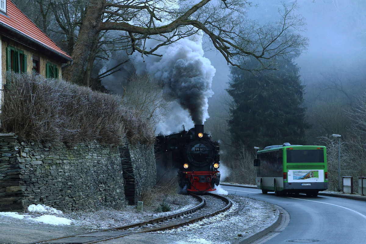 Scheinanfahrt von 99 6101 und 99 5901 mit IG HSB-Sonder-PmG am 14.02.2015 in Mägdesprung. (Bild 1) Hier kommt es gerade zum Treffen von zwei Generationen der Beförderungstechnik, welches durch den sich mit dem im Tal liegenden Morgennebel vermischenden Abdampf der Loks, in ein etwas geheimnisvolles Licht getaucht wird.