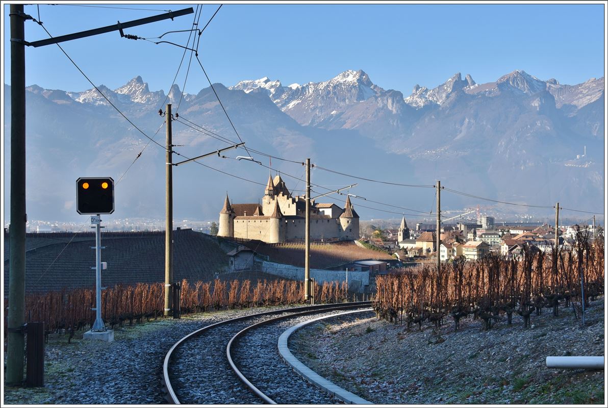 Schloss Aigle im ersten Licht des Tages und das zur Mittagszeit.  Im Vordergrund verläuft das Trassee der Bahn nach Les Diablerets. Die Signale sind jetzt grösstenteils in Betrieb. (14.12.2016)