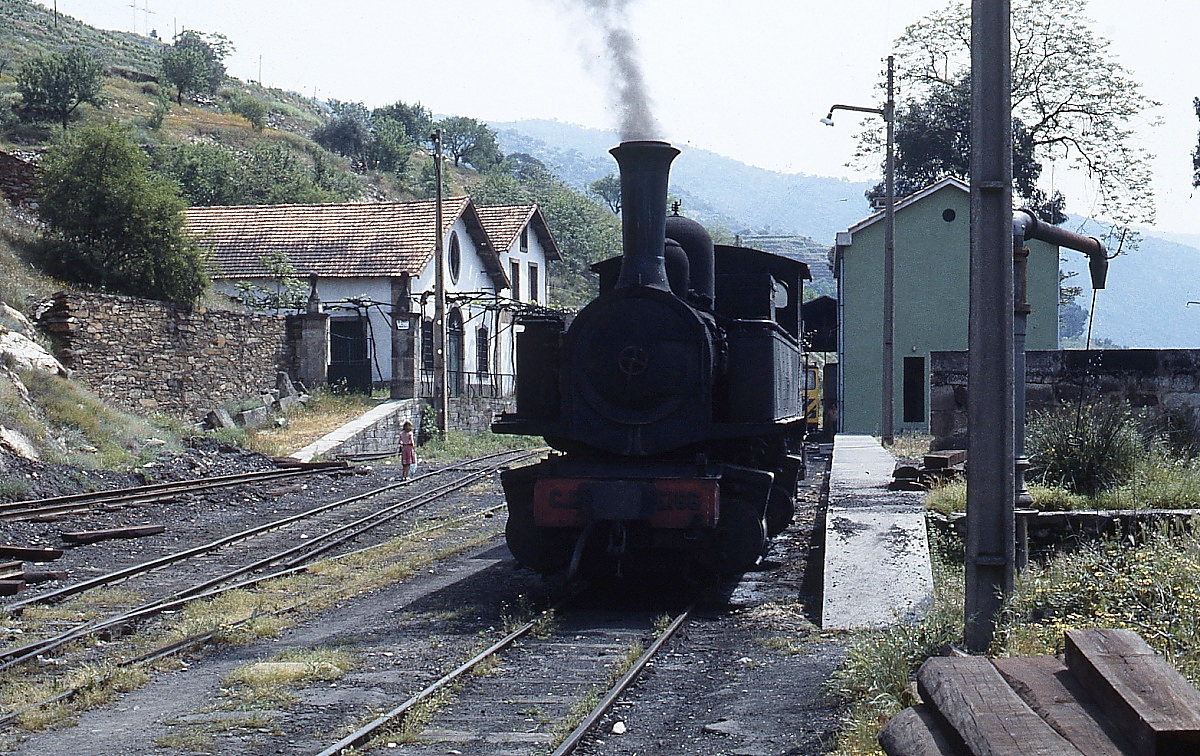 Schmalspurdampflokomotiven in Portugal: CP E 166 (3 069 166-9) unter Dampf am 27.04.1984 in Tua. Insgesamt wurden zehn dieser B'Bn4vt-Loks von Henschel zwischen 1905 und 1908 an die Caminhos de Ferro do Estado Minho e Duoro (dort Nr. 401-410) geliefert. Zwar kam die Lok nach Auskunft eines Bahnmitarbeiters nicht mehr auf der Strecke zum Einsatz, wurde aber noch für den Rangierdienst im Schmalspurteil des Bahnhofes Tua benötigt.