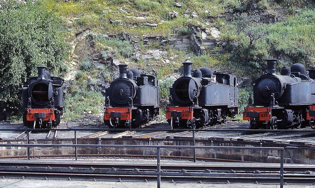 Schmalspurdampflokomotiven in Portugal: Rund um die Drehscheibe in Regua waren am 27.04.1984 mehrere 1'BCn4vt-Loks der Reihe E 201-216 abgestellt, hier von links nach rechts E 206, E 216, E 212, E 211. Diese Loks wurden von Henschel zwischen 1911 und 1923 an die Caminhos de Ferro do Estado Minho e Duoro (dort Nr. 451-466) geliefert.