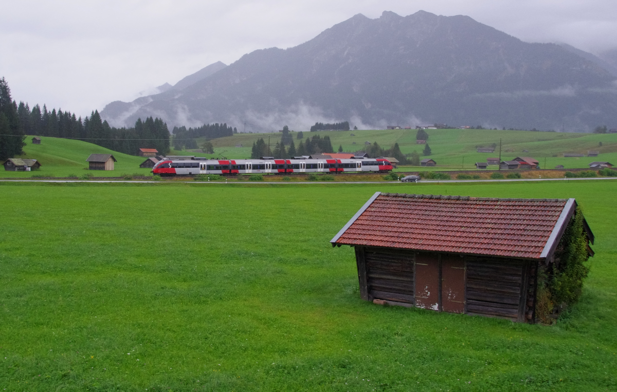 Schön ist, wenn man trotz Regenwetter einen trockenen Standort mit Blick auf die Bahn hat. Ein ÖBB Talent fährt an unserer Ferienwohnung vorbei, Innsbruck - Garmisch-Partenkirchen, so lautet die Relation. Bahnstrecke 5504 München - Mittenwald kurz vor Klais. 17.09.2016