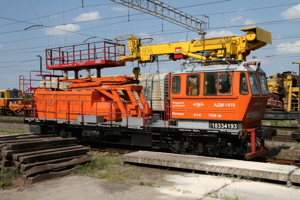Schön orange gelber Wagen mit Hebebühne zwischen Poltava und Krementschuk. Über die genaue Typenbezeichnung darf spekuliert werden, sind doch sehr viele Nummern und kyrillische Buchstaben angebracht. Bild vom 10.06.2015.