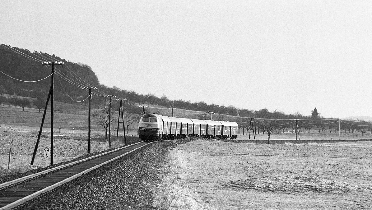 Schon immer hatte die Strecke Stockheim - Bad Vilbel - Frankfurt Bedeutung f�r den Pendlerverkehr in die Mainmetropole, aber lange Zeit beschr�nkte sich der Verkehr auf Mo-Sa mittags. Die Gie�ener 216 107 zieht eine Umbauwagengarnitur bei Glauberg in Richtung Stockheim, wo der Zug bis zur R�ckfahrt am Montag abgestellt wird (April 1982).