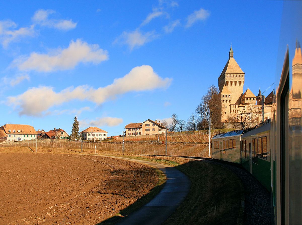 Schon Tausende Male photographierter Standort - und doch sind jedes Mal Licht und Farben anders. Heute weht ein kräftiger Föhn. Zug mit Triebwagen 31 vor Vufflens. 3.Februar 2017 
