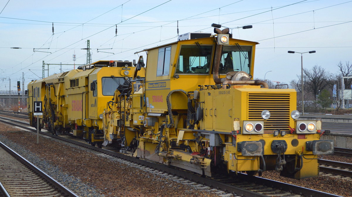 Schotterplanier- und Profilierungsmaschine P&T SSP 110 SW (99 80 9425 005-2 D-BRS) mit einer Hochleistungs-Universal- Nivellier-Richt-Stopfmaschine vom Typ MATISA B 66 UC  am Haken der Fa. STRABAG am 18.01.20 Bf. Flughafen Berlin Schönefeld.
