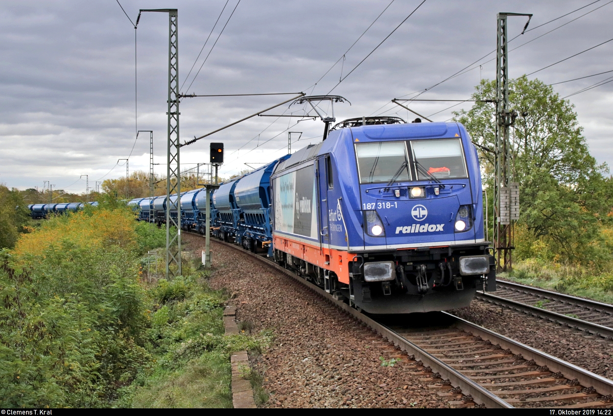Schüttgutzug mit 187 318-1  In Thüringen zu Hause. In Europa unterwegs.  der Raildox GmbH & Co. KG durchfährt im einheitlichen Blau den Hp Magdeburg Herrenkrug auf der Bahnstrecke Berlin–Magdeburg (KBS 201) Richtung Magdeburg-Neustadt.
Aufgenommen am Ende des Bahnsteigs 2.
[17.10.2019 | 14:22 Uhr]