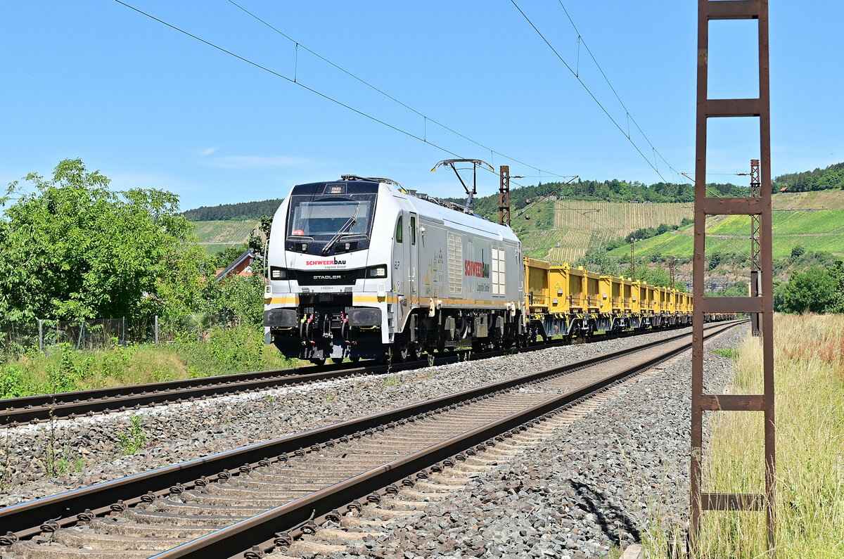 Schweerbau 159 236 ist mit Containern von DB Bahnbau Gruppe in Himmelstadt gen Retzbach-Zellingen fahrend zusehen am Dienstag den 28.6.2022