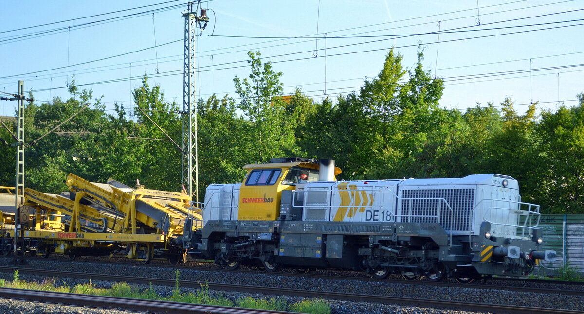 SCHWEERbau mit ihrer vossloh DE18 (NVR:  92 80 4185 023-3 D-SBAU ) mit einem Gleisbauzug  Materialförder- und Silowagen am 25.08.21 Vorbeifahrt Bf. Hamburg-Harburg.