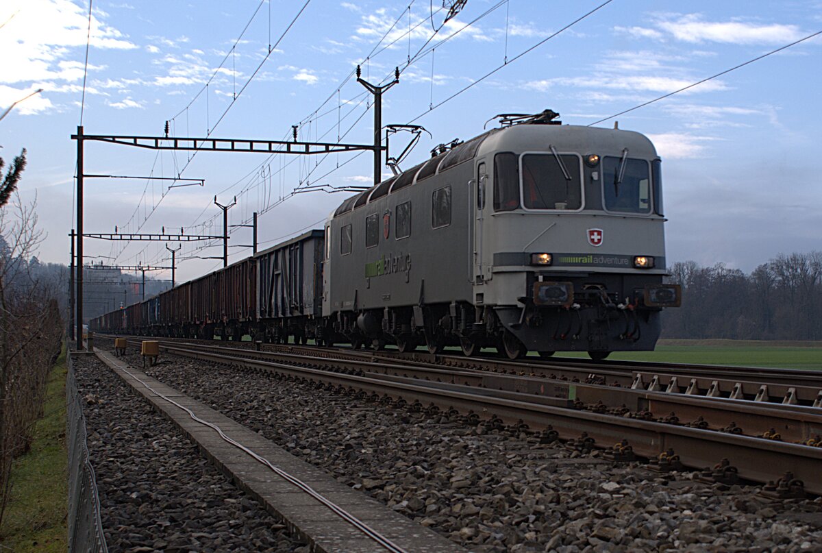 Schweizer Zucker AG, Zuckerfabrik Aarberg, Kampagne 2025: Re 620 003-4 + 27 Eaos/Eas, Zug 69417 Aarberg-Islikon, Leerwagenzug zum Abholen von Rüben in der stillstehenden Zuckerfabrik Frauenfeld, Busswil, 17. Dezember 2025.