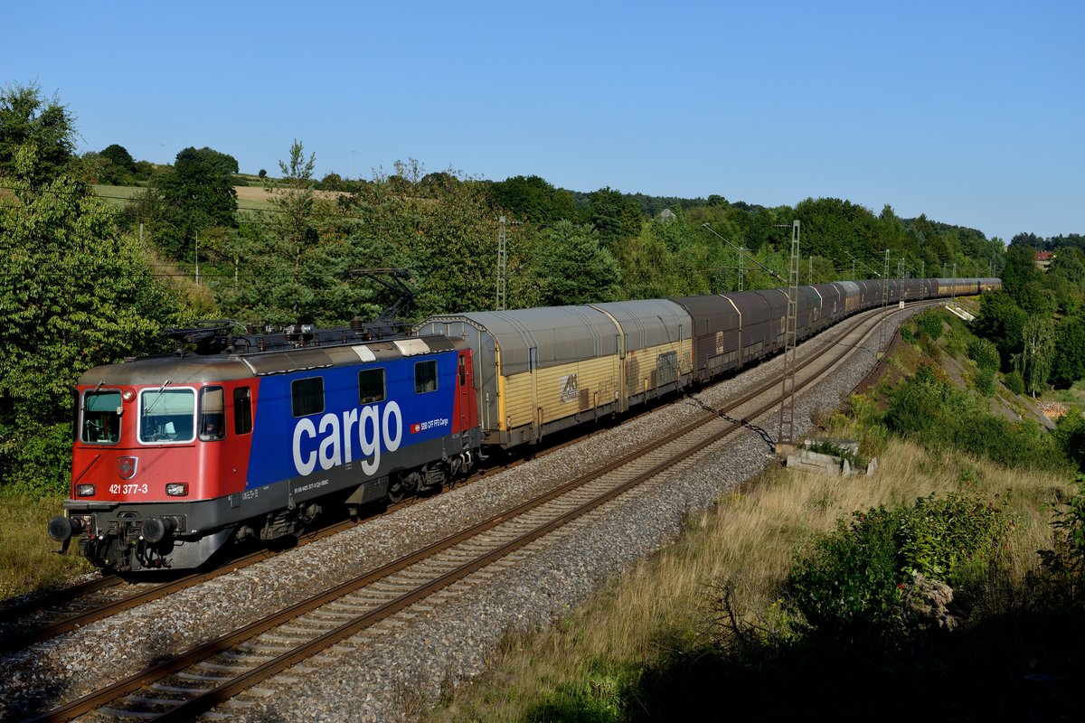 Sehr erfreulich finde ich den Einsatz der SBB Cargo 421-er für TX Logistik. Hauptsächlich kommen die formschönen Re 4/4 in der attraktiven SBB Cargo Lackierung vor Autozügen der Firma Altmann zum Einsatz. Damit werden BMW Neuwagen von München, Dingolfing oder Regensburg nach Bremerhaven transportiert, wo diese dann auf Schiffe umgeladen werden, welche die Autos anschließend in die jeweiligen Exportländer bringen. Am 16. August 2013 beförderte die 421 377 einen solchen Zug. Aufgenommen bei Laaber.