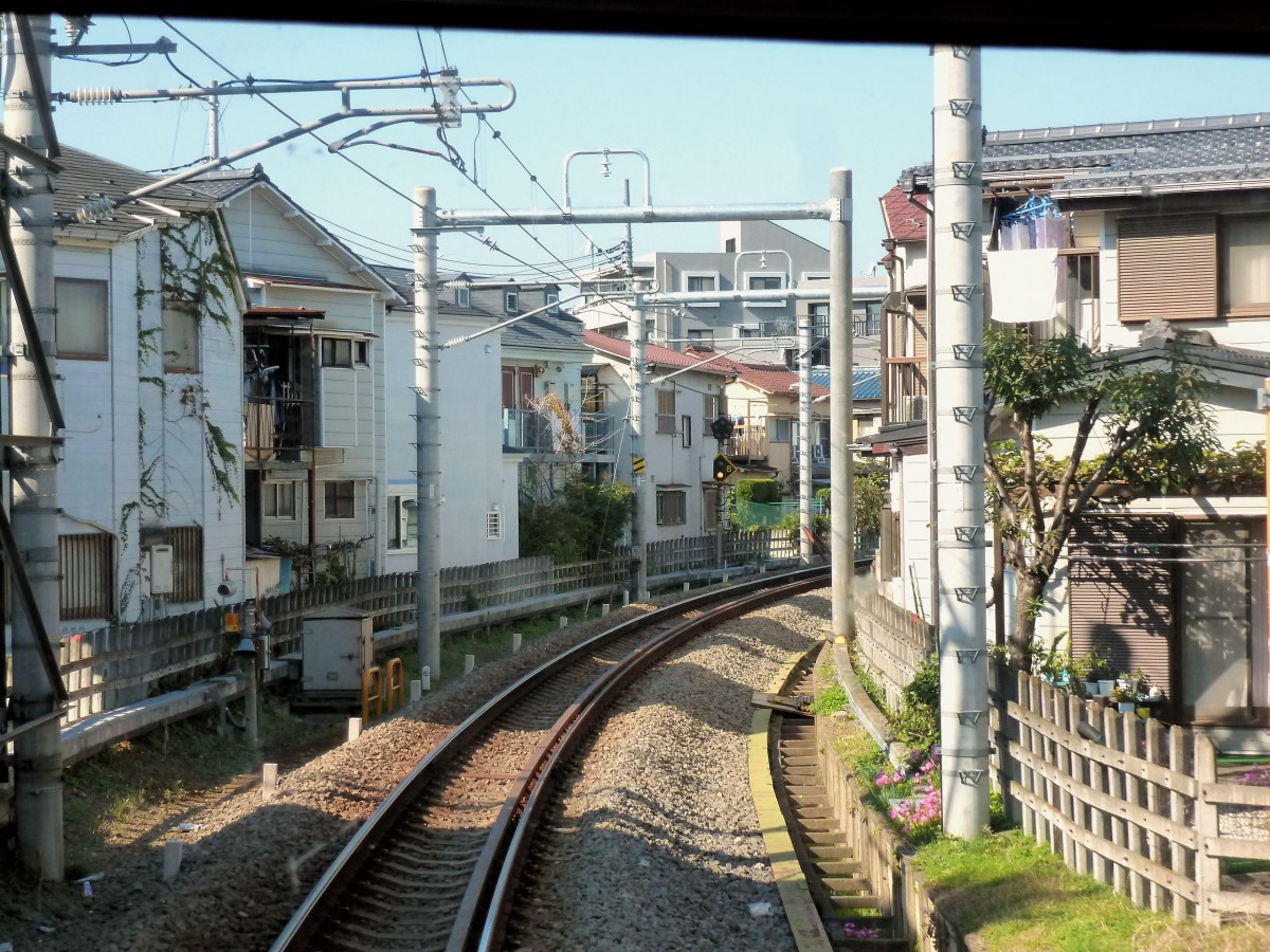 Seibu-Konzern, Toshima-Linie (1 km lang): Eine typische Seibu-Linie eng an den Häusern vorbei. Durch die verglaste Führerstandrückwand des Zuges 3011. 31.Oktober 2011. 