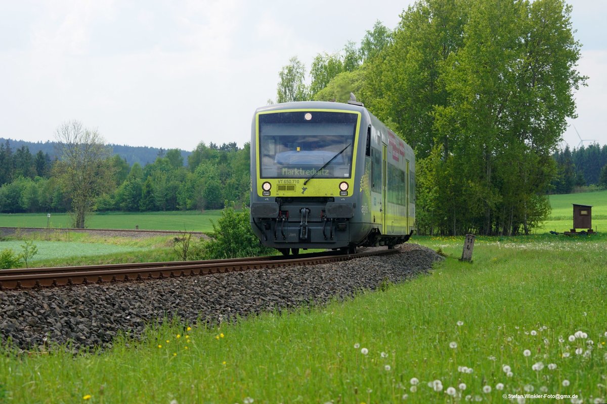 Seit 2011 fährt Agilis auch auf der Nebenbahn nach Bad Steben. Hier kommt 650710 die Steigung bei Stegenwaldhaus hoch und fährt am 19. Mai 2017 nicht nur an einer transportablen Jagdkanzel, sondern auch an der fast abgeblühten Löwenzahn-Wiese vorbei...