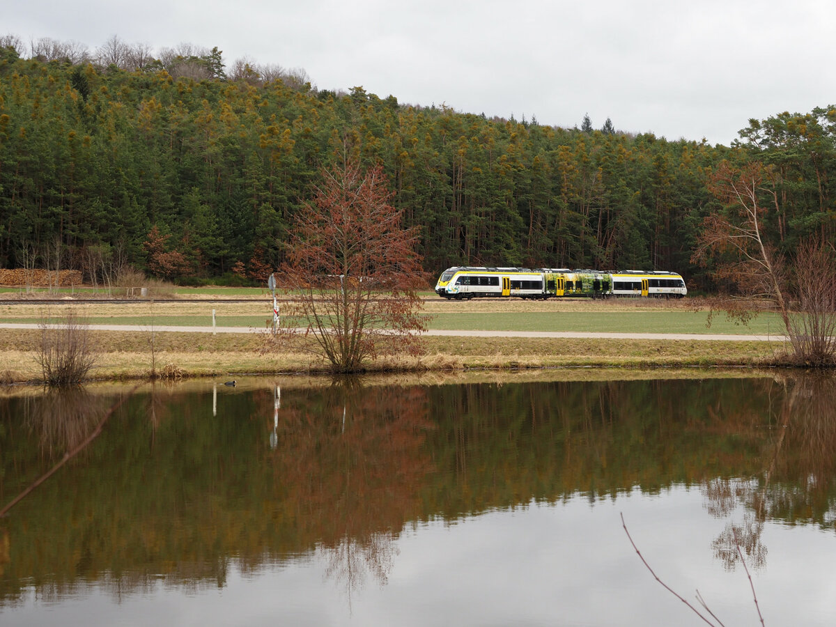 Seit dem 5.2.22 fährt am Wochenende zwischen Gunzenhausen und Pleinfeld auf der Seenlandbahn der BEMU von Alstom (ex Bomardier, siehe auch Fahrzeuganschriften). 
Hier passiert der Zug einen Weiher nahe Langlau.

Langlau, der 26.02.2022