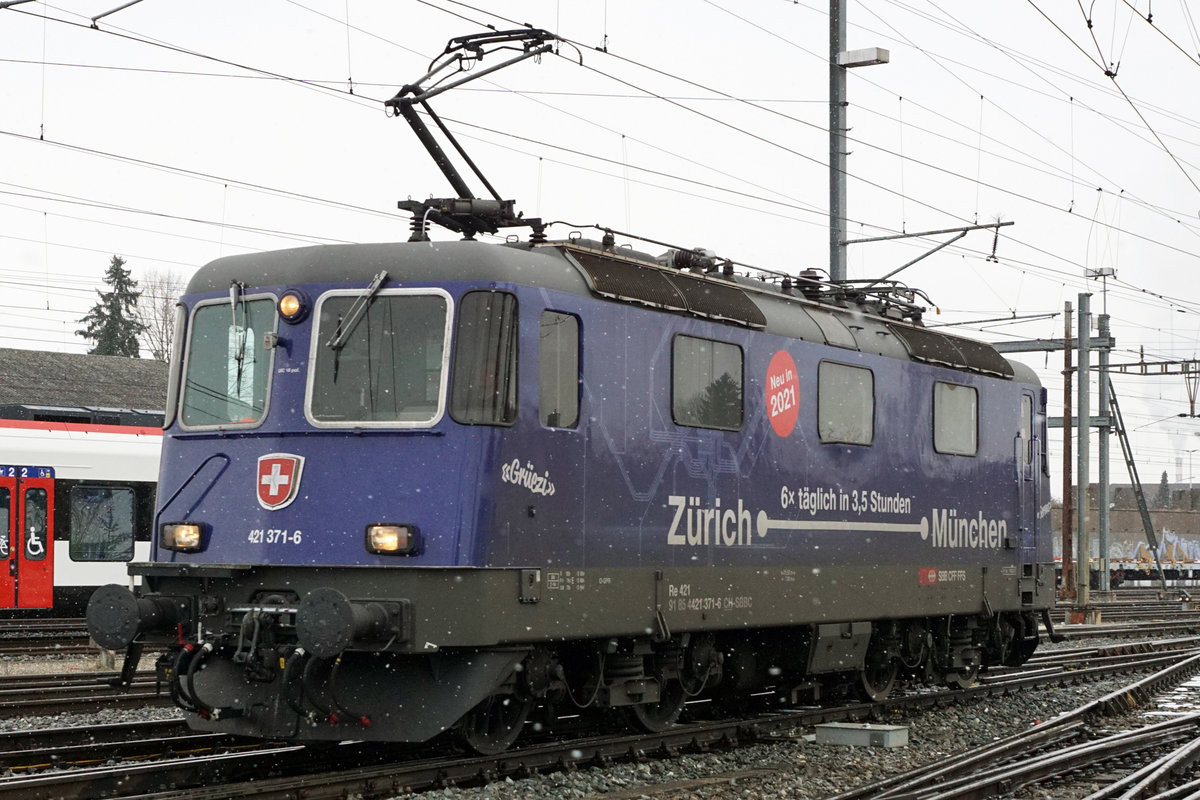 Seit dem Fahrplanwechsel vom 13. Dezember 2020 können die ehemaligen  Münchnerinnen  im Güterbetrieb beobachtet werden.
Re 421 371-6 auf Rangierfahrt im Güterbahnhof Solothurn am 6. Januar 2021.
Fotostandort öffentlich zugängliche Wiese. Bildausschnitt Fotoshop.
Foto: Walter Ruetsch 