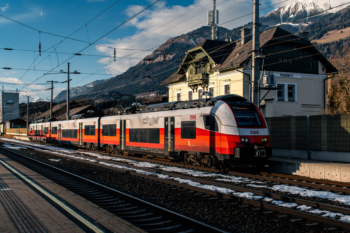 Seit dem Fahrplanwechsel im Dezember 2025 wurde im Zuge der Inbetriebnahme der Koralmbahn auch das S-Bahn-Netz in Kärnten neu strukturiert. Mit der Verlängerung der S1 bis Pusarnitz ist der Ort nun offiziell Teil des S-Bahn-Netzes. Die Linie verkehrt von Pusarnitz über Spittal, Villach und Klagenfurt bis nach Wolfsberg.

Allerdings wird der Abschnitt zwischen Pusarnitz und Villach lediglich von Montag bis Freitag von ca. 6 Uhr bis 20 Uhr bedient. Da nun auch alle beiden Regionalzugpaare über Mühldorf-Möllbrücke und Kolbnitz nach Mallnitz-Obervellach nur mehr unter der Woche verkehren, bleibt Pusarnitz am Wochenende weiterhin komplett ohne öffentliche Anbindung.

Hier zu sehen ist ÖBB 4746 103-2, der am 10.02.2026 nach einer kurzen Wende wieder abfahrtsbereit im Bahnhof Pusarnitz bereitsteht.

Zug: S1 4675
Laufweg: Pusarnitz ➤ Spittal-Millstättersee ➤ Villach Hbf ➤ Klagenfurt Hbf ➤ Kühnsdorf-Klopeiner See ➤ Bleiburg ➤ St. Paul im Lavanttal ➤ Wolfsberg