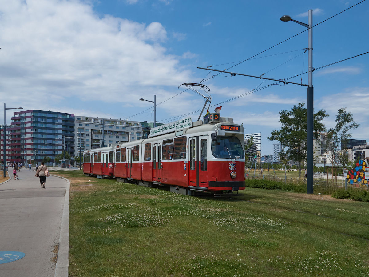 Seit Dezember 2019 erschließt die Straßenbahnlinie D das Sonnenwendviertel in Wien. Am 30.6.2021 war ein E2-c5-Zug, bestehend aus E2 4025 und c5 1425 auf dem Weg zur Absberggasse und hat gerade die Haltestelle Hlawkagasse verlassen.