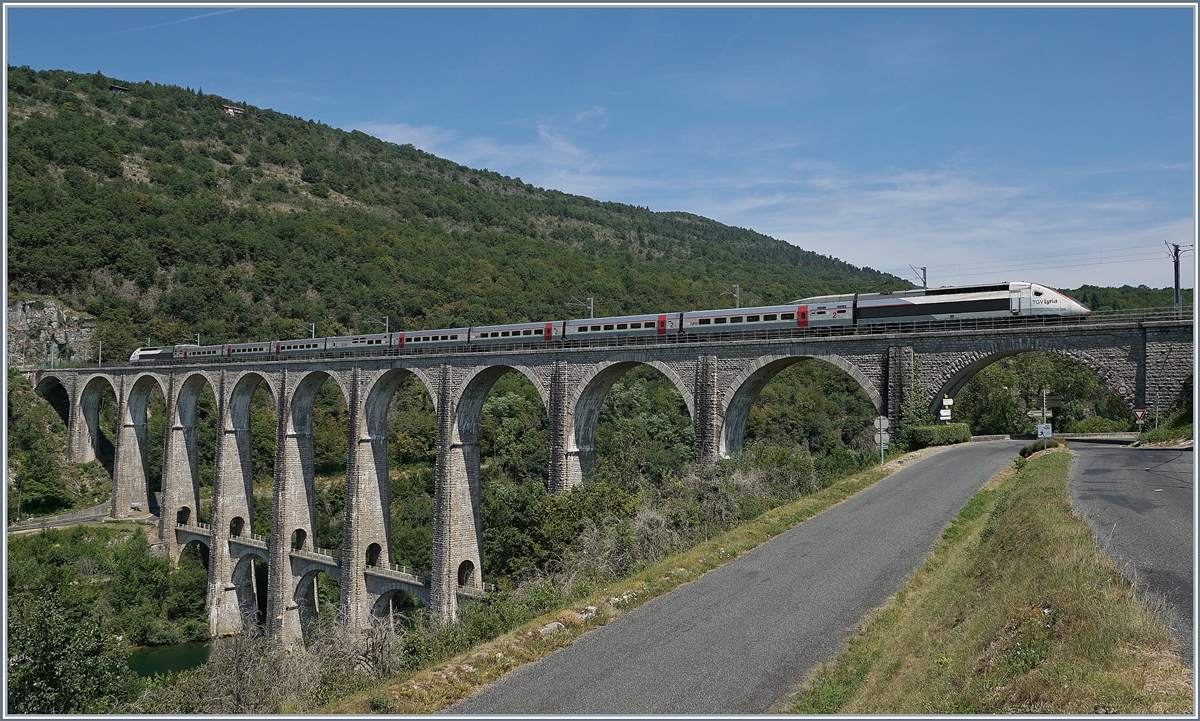 Seit Ende 2010 nehmen die TGV Züge von Genève nach Paris den Weg über die dafür hergerichtete Strecke Bellegarde - Nantua - Bourg en Bresse, die zwar keine hohen Geschwindigkeiten erlaubt, aber dank der eingesparten 47 km gegenüber der Strecke via Culoz doch eine erhebliche Zeitersparnis bringt. 

Im Bild der TGV-Triebzug 4401 als TGV Lyria 9770 von Genève nach Paris auf dem 269 Meter langen Viaduc de Cize-Bolozon welches die Ain überbrückt. 

17. Juli 2019