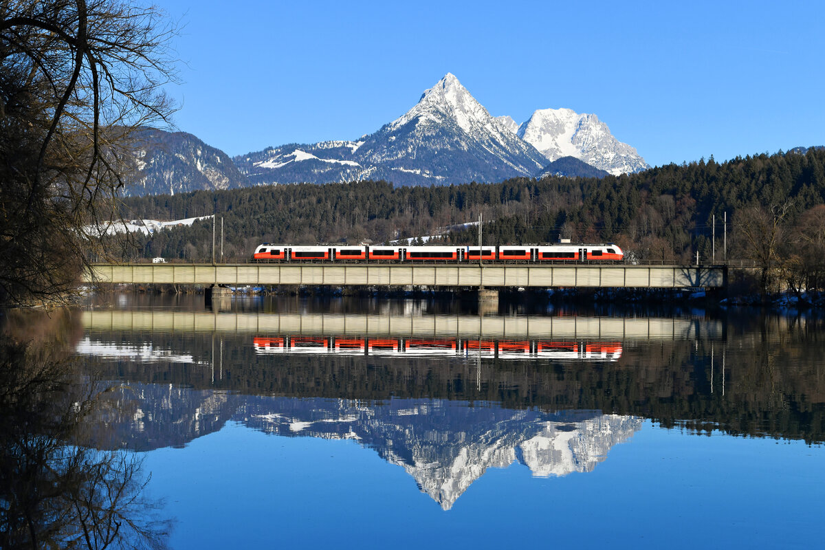 Seit Fahrplanwechsel kommt nun auch der  cityjet  bis Kufstein. Am 12. Februar 2022 fotografierte ich den 4746.008 als CJX 6108 auf der Fahrt nach Innsbruck HBF beim Überqueren des Inns in der Nähe von Langkampfen. Neben dem modern Nahverkehrs-Triebzug spiegelt sich auch die imposante Pyramidenspitze im Wasser.