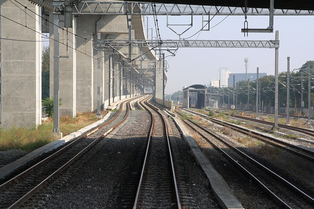 Seit der Inbetriebnahme der Krungthep Aphiwat Station der SRT (vorher Bang Sue Grand Station genannt) am 19.Jänner 2023 verkehren die Zügen der Northern und Northeastern Line welche in Hua Lamphong beginnen/enden zwischen der Nikhom Rotfai Km. 11 Station und Rangsit Station auf der Hochlagetrasse. - Das Bild vom 10.Dezember 2023 zeigt die Rampe nach der Nikhom Rotfai Km. 11 Station zur Hochlagetrasse und rechts im Bild die alte Trasse der Northern Line.