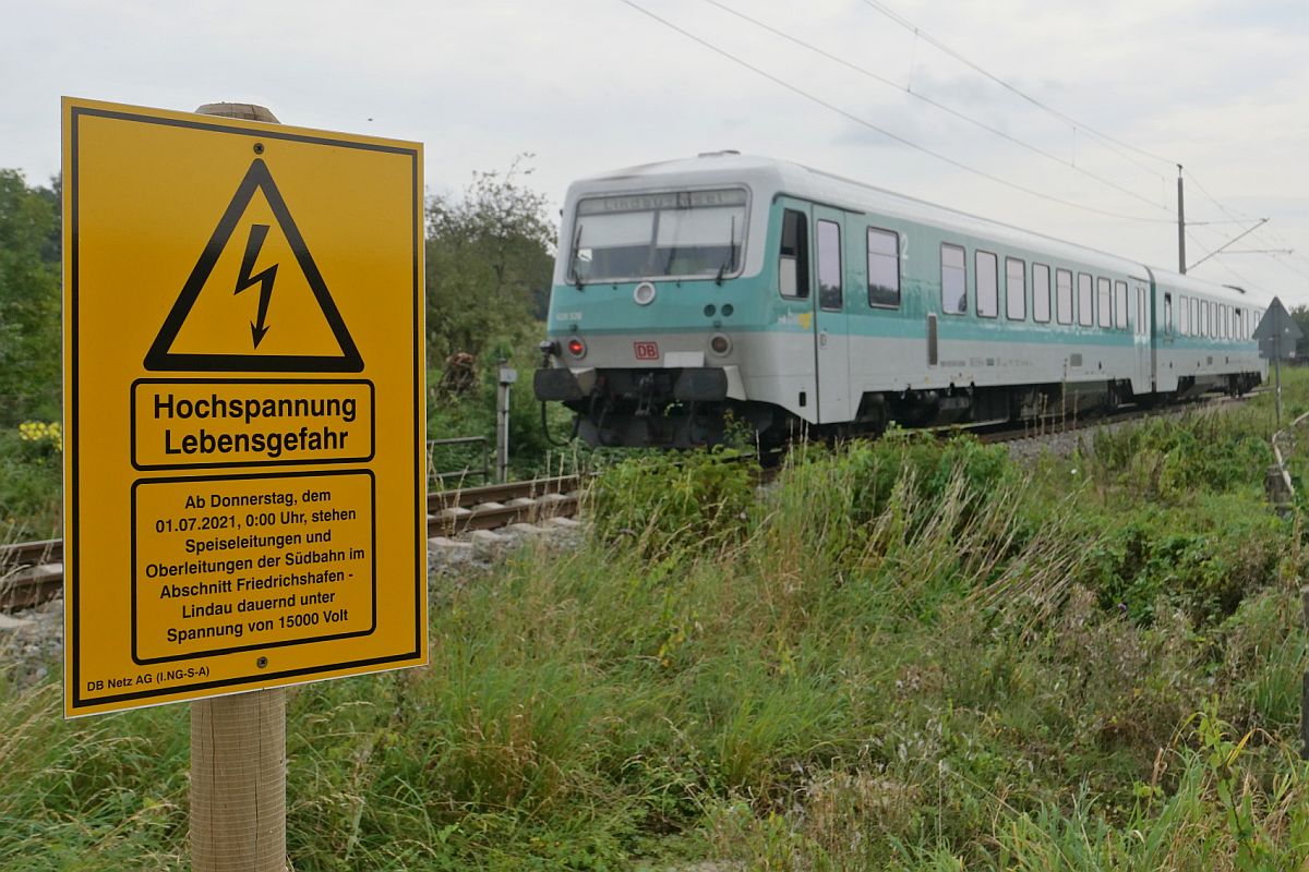 Seit Juni 2021 stehen an allen Bahnbergngen und in allen Bahnhfen entlang der jetzt elektrifizierten Bodenseegrtel-/Sdbahn zwischen Ulm und Lindau diese Warnschilder. Nhe Eriskirch, 15.09.2021.