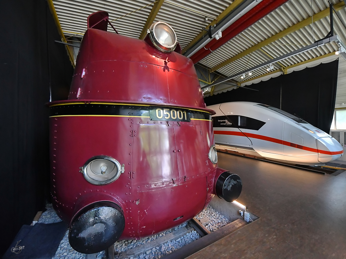 Seite an Seiten stehen die Stromliniendampflokomotive 05 001 und eine Designstudie für den ICE 4. (DB-Museum Nürnberg, Juni 2019)