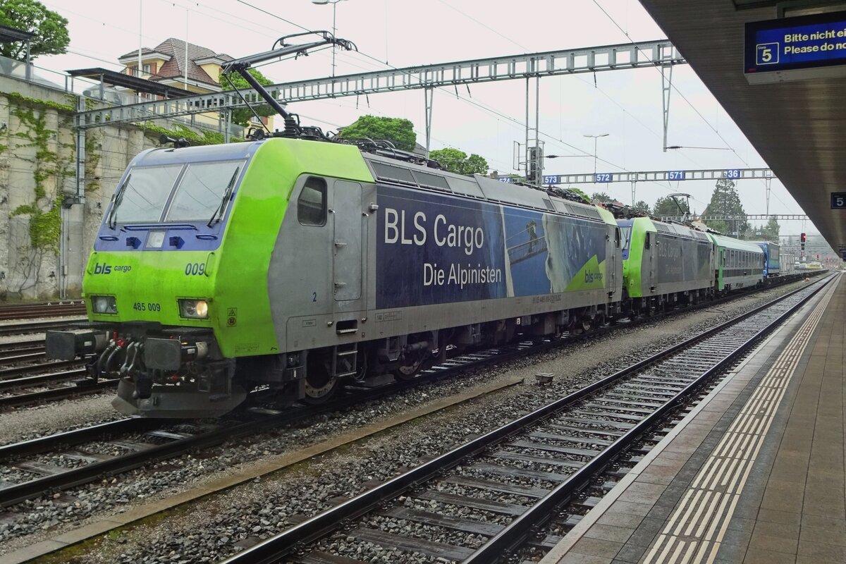Selber Lok, neue Aufkleber: BLS 485 009 beklimmt die Alpen in Spiez am veregneten 28 Mai 2019.