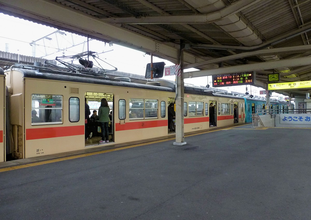 Serie 105 (4-türig): In Japan braucht man sich nicht um Niederflureinstiege zu kümmern. Eher fragt sich der Passagier, wo er/sie einen Sitzplatz findet. Doch in diesen Zügen fährt man meist nicht weit, und da wird sich schon etwas geben. Motorwagen KUMOHA 105-506 im Städtchen Tenri, südlich von Nara. 3.Dezember 2012. 