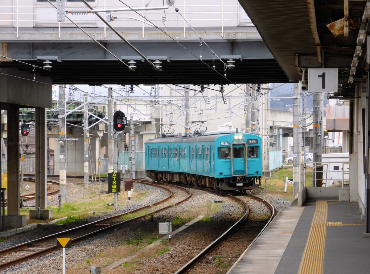 Serie 105 (viertürig) - mit dem Regionalzug durch die Dörfer im Herzen Japans: Einfahrt des Zweiwagenzugs KUHA 105-8 (ehemaliger Steuerwagen eines S-Bahnzugs aus Tokyo) + KUMOHA 105-518 (ehemaliger Zwischenmotorwagen eines Tokyo-S-Bahnzugs mit angebautem, neuen Führerstand). Sakurai, 24.März 2015.    
