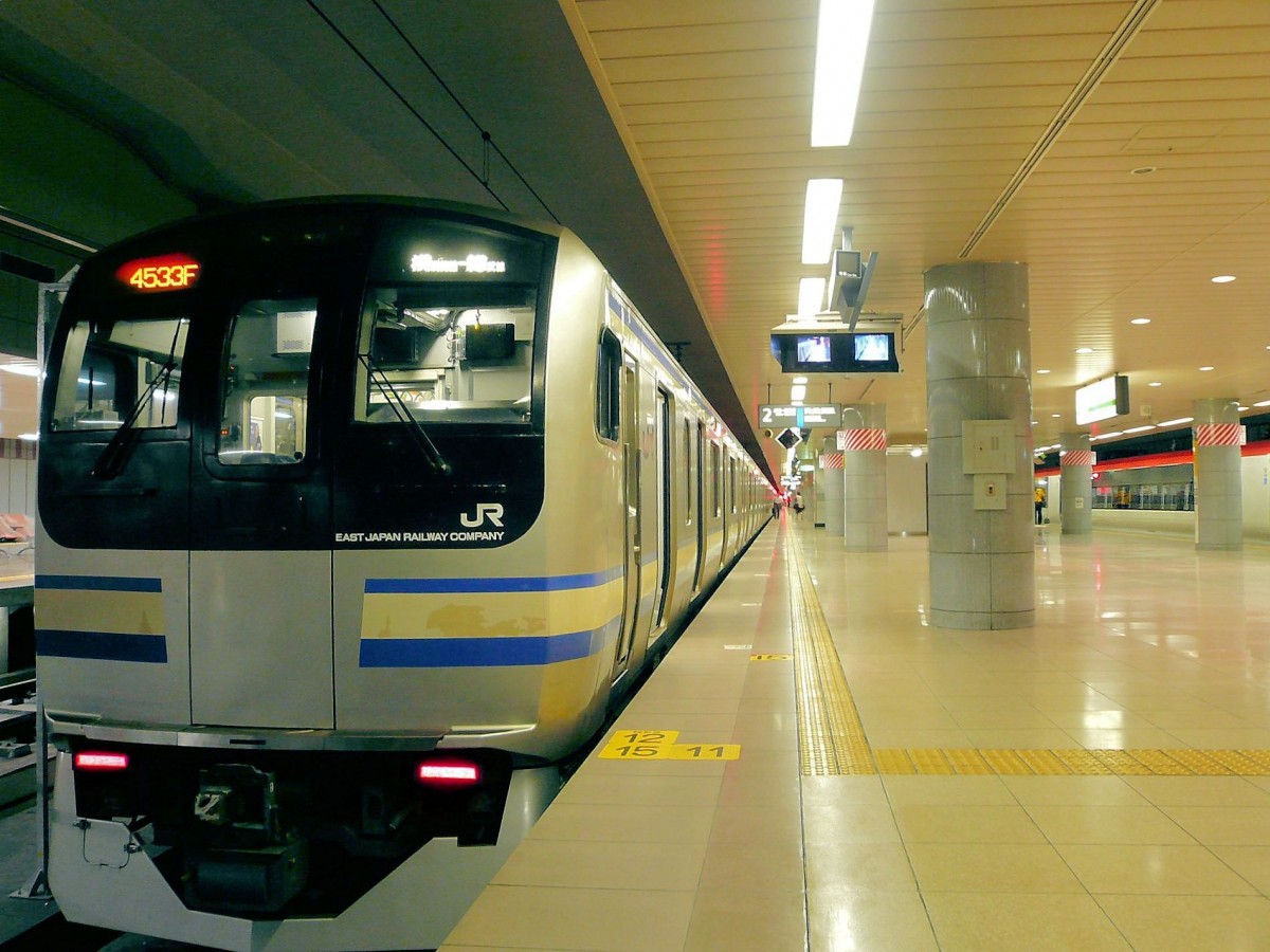 Serie 217: An der Endstation im Internationalen Flughafen Tokyo-Narita wartet der Eilzug (Serie 217 Zug Nr. 2, Steuerwagen KUHA 217-2). Rechts im Hintergrund ist der zuschlagspflichtige Expresszug fr die gleiche Strecke zu sehen. Auffallend die sanften, hellen Farbtne des Raums und des Bodens, im Gegensatz zu den hufig grauen oder dunklen Farben in Europa. Man beachte auch die Fernsehkameras, mit denen der Schaffner - der immer stramm am Zugsende steht - das Ein- und Aussteigen berwachen kann.  11.Juli 2010. 