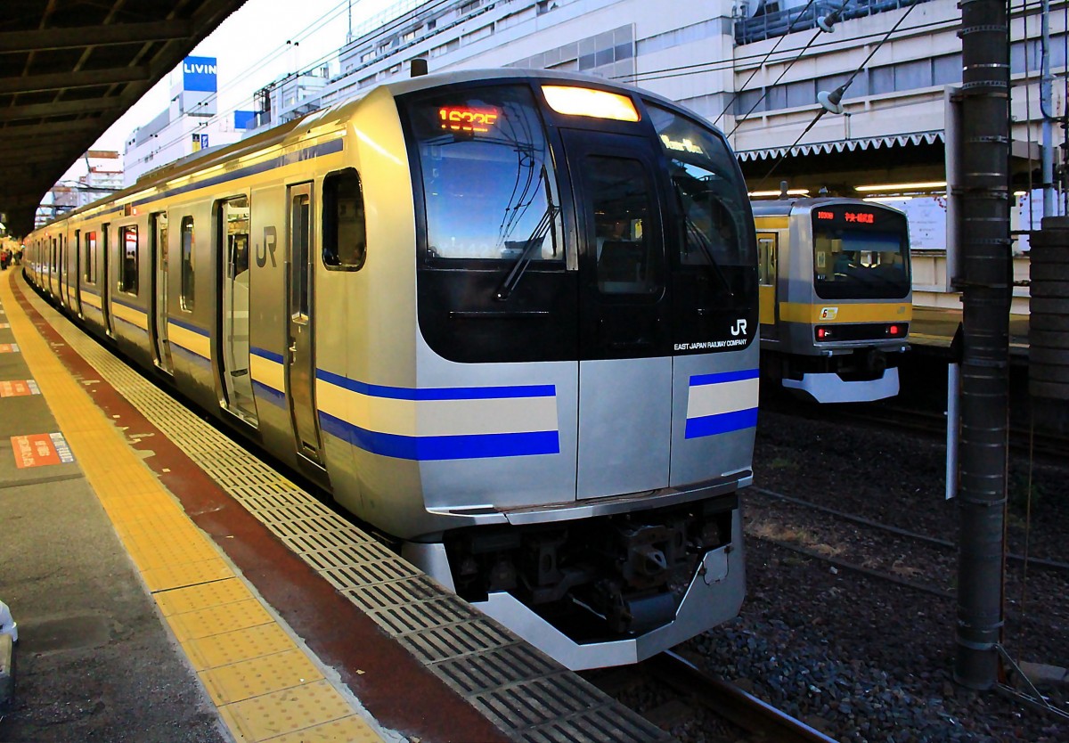 Serie 217: Auf der Strecke nach Chiba und dem Internationalen Flughafen Narita stehen in Tokyo-Kinshichô Zug Nr.2 der Eilzug-Serie 217 (Steuerwagen KUHA 216-2002) und daneben ein Zug mit Halt an allen Stationen auf seiner eigenen Doppelspur. 17.Oktober 2014. 