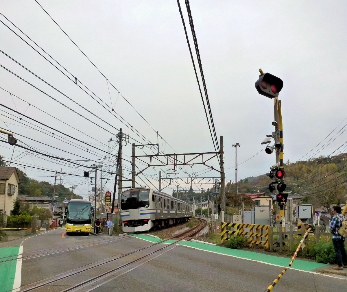 Serie 217 Eilzüge: bei Kamakura südöstlich von Tokyo. Im Bild Zusatzzug Nr.11 (kuha216-1011), welcher die letzten 4 Wagen eines 15-Wagenzugs bildet. Gut zu sehen die beiden leuchtenden Pfeile an der Schranke, die anzeigen, dass sich Züge von beiden Seiten nähern. 30.November 2011.  YOKOSUKA-LINIE 