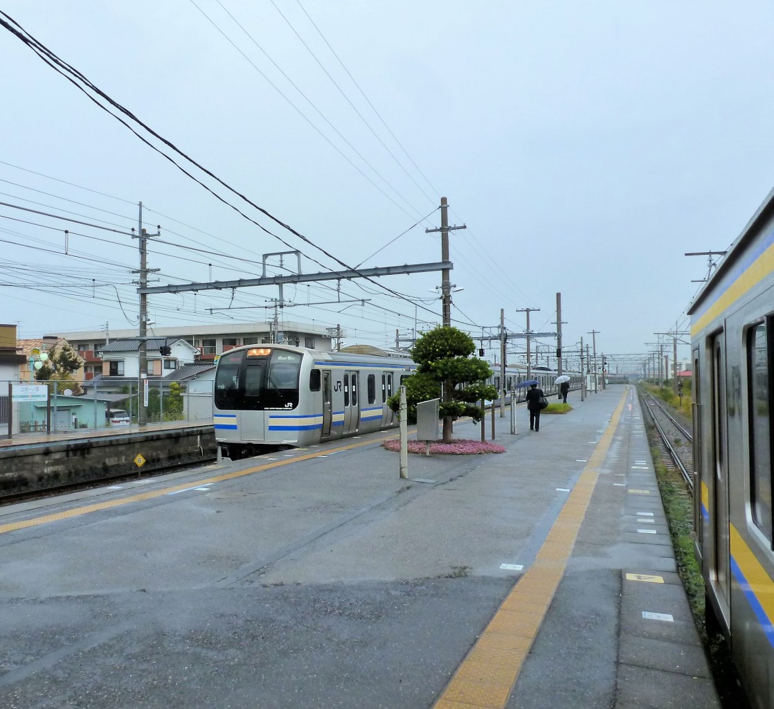 Serie 217 Eilzüge: Zug Nr. 23 (Frontwagen kuha217-23) zieht bei strömendem Regen in seine Endstation Kazusa Ichinomiya auf der Bôsô-Halbinsel (östlich von Tokyo) ein. Derweil wartet rechts ein kurzer Regionalzug, um die kleine Zahl Fahrgäste weiter zu befördern, die Küste der Halbinsel entlang. 11.November 2011.  