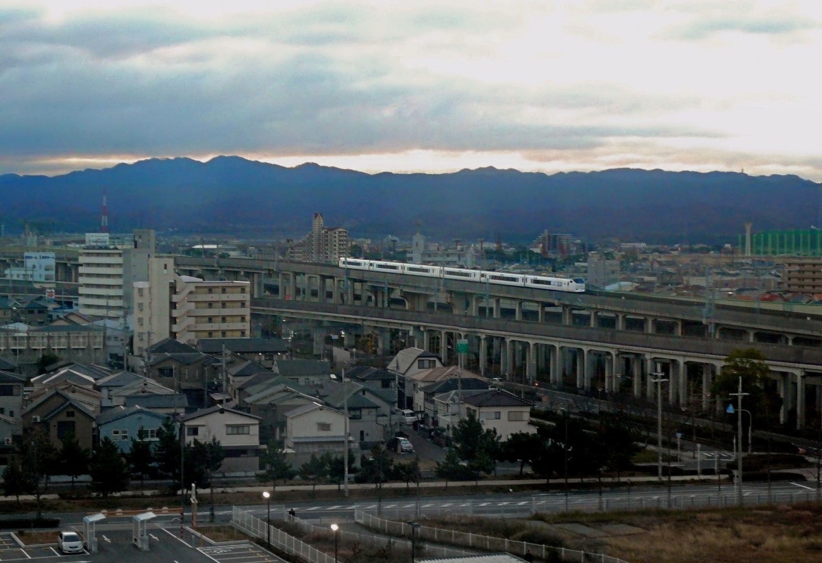 Serie 281: In den ersten Sonnenstrahlen des frühen Morgens kommt ein Zug über die grosse Brücke, die in ihrer Fortsetzung aufs Meer hinaus und zum Flughafen Kansai führt. 8.Dezember 2010.  