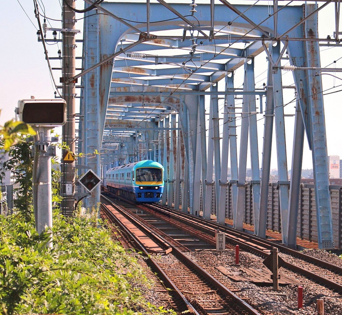 Serie 485,  Joyful Train : Der Ausflugszug  New Nanohana  wurde 1997 aus Bestandteilen eines Zweistromzuges Serie 481/485 aufgebaut. Hier berquert er auf der S-Bahn Musashino Linie den Fluss Edogawa im Norden von Tokyo, Misato, 17.Oktober 2014.  nanohana  bedeutet  Rapsblte , eine markante Pflanze im Nordosten von Tokyo. 