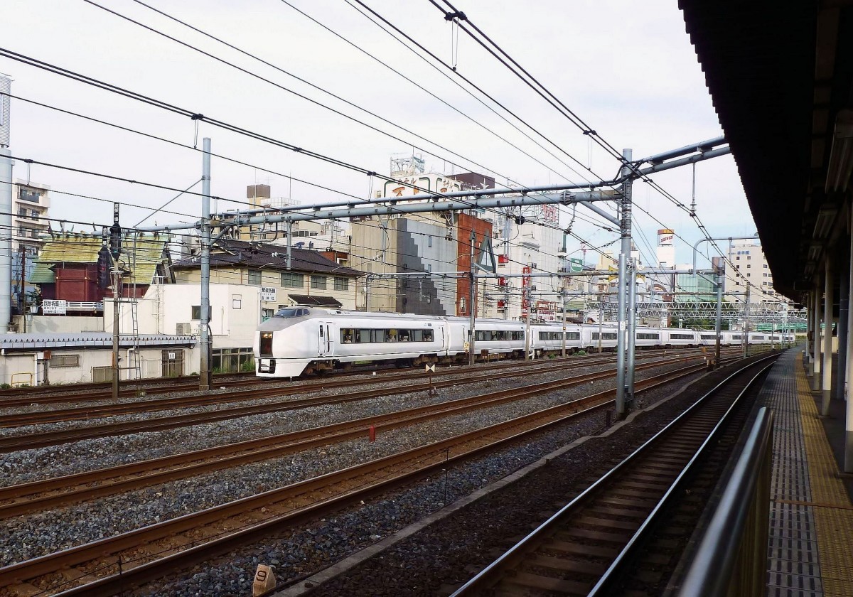 Serie 651: Zug Nr. 6 mit dem Vierwagenteil vorn (geführt von Steuerwagen KUHA 651-106) in Tokyo-Uguisudani. Im Hintergrund wirkt der alte Holzschrein inmitten der Hotels und Betonklötze eigenartig fremd. 24.Juni 2011. 
