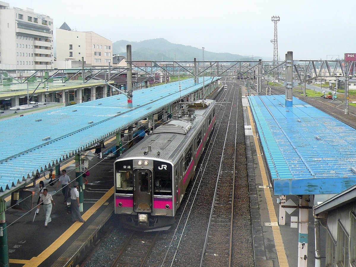 Serie 701 des Bezirks Akita - auf der alten Haupttransversale Tokyo-Yamagata-Akita: Die Gebirgsstrecke aufs Hochplateau von Yamagata (bis zum Ort Shinjô) hinauf wird heute vom Shinkansen bedient; von da an geht die alte Linie in den äussersten Nordwesten auf 1067mm-Spur durch wildes Gebirge nach Akita. Die Regionalzüge werden hier von Zweiwagenzügen Serie 701 geführt; im Bild Zug 701-17 in Yokote im Hochland der Präfektur Akita. 10.Juli 2010.  