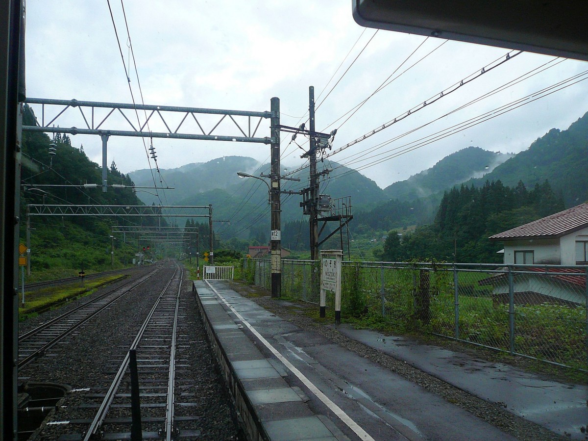 Serie 701 des Bezirks Akita - auf der alten Haupttransversale Tokyo-Yamagata-Akita: Die letzte Station südlich des Scheiteltunnels ist das einsame und düster wirkende Nozoki. Aufnahme aus Zug 701-27, 10.Juli 2010.   