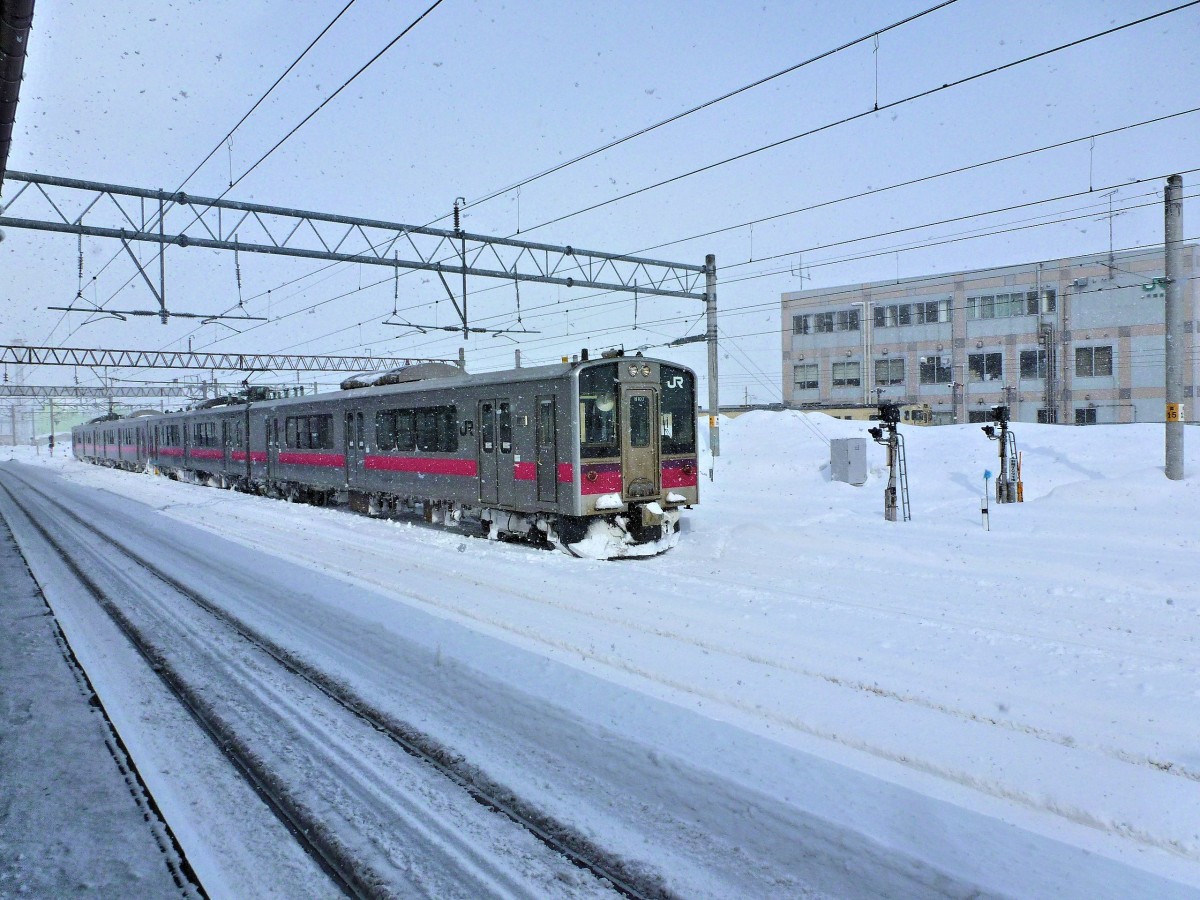 Serie 701 des Bezirks Akita - durchs Gebirge von Akita nach Aomori: In Hirosaki machen die beiden Züge 701-103 und 701-16 Mittagspause. Der Himmel zeigt sich zwar blau, doch schneit es. 11.Februar 2013. 
