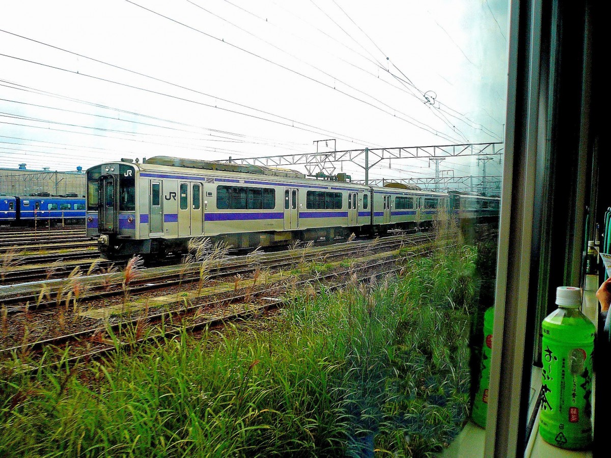 Serie 701 des Bezirks Morioka: Aomori, die nördlichste Stadt der japanischen Hauptinsel - hier wird umgestiegen in den Intercity von JR Hokkaidô, der 53 km weit tief unter dem Meeresboden die Fahrgäste auf die Nordinsel Hokkaidô bringen wird. Während man zu einer Flasche heissen japanischen Grüntees Hokkaidô entgegengleitet steht draussen nach getaner Arbeit der Lokalzug 701-1004 in der Abstellanlage Aomori. 24.August 2008. 