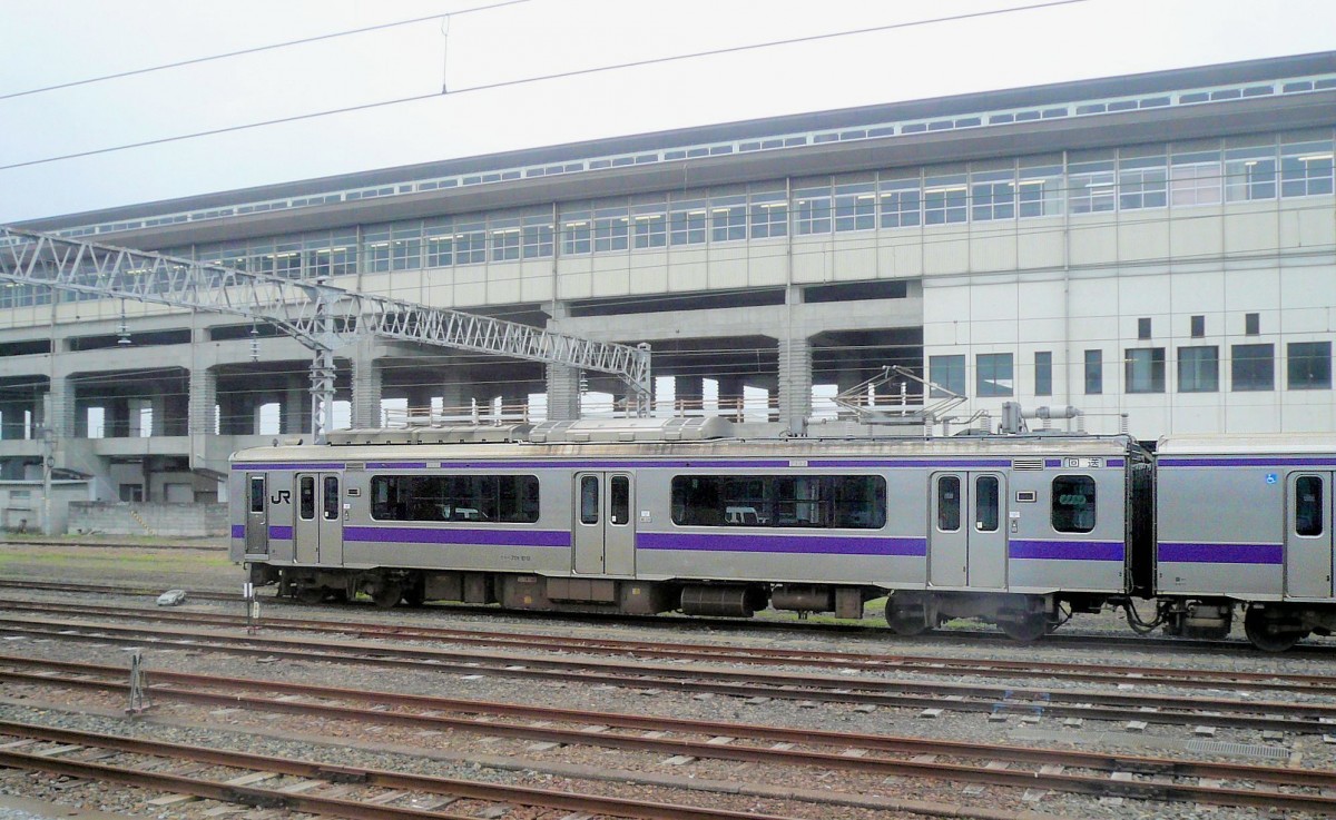 Serie 701 des Bezirks Morioka - im Schatten des Shinkansen: Der Bau des  Hochgeschwindigkeitszugs Shinkansen hat eine ungeheure Zubetonierung der meist dörflichen Landschaft Nordost-Japans mit sich gebracht. Hier steht Zug 701-1012 unterhalb des Shinkansen-Bahnhofs auf den alten Gleisen von Ichinoseki, 9. Juli 2010. 