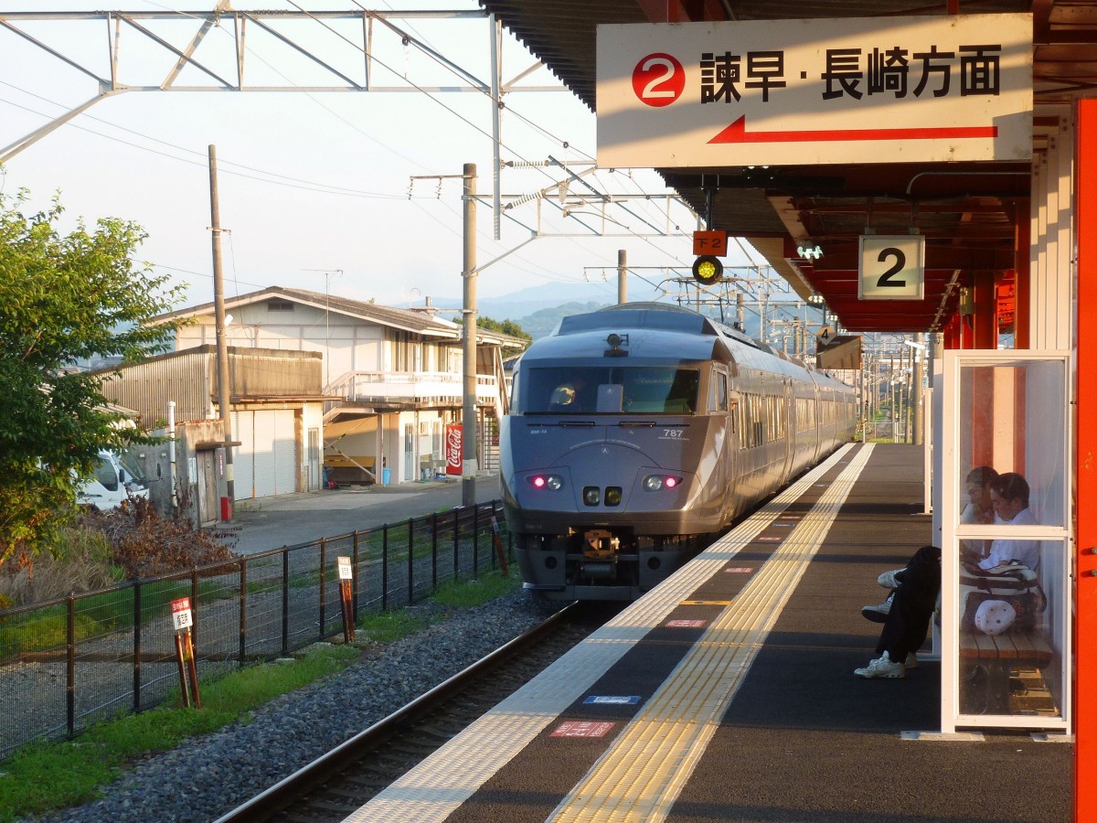 Serie 787: An einem sonnigen Morgen fährt ein Sechswagenzug der Nagasaki-Linie aus Hizen Kashima aus, am Schluss KUMOHA 786-14. Die Schüler sind nicht interessiert und warten auf den Lokalzug. 6.August 2013. NAGASAKI-HAUPTLINIE