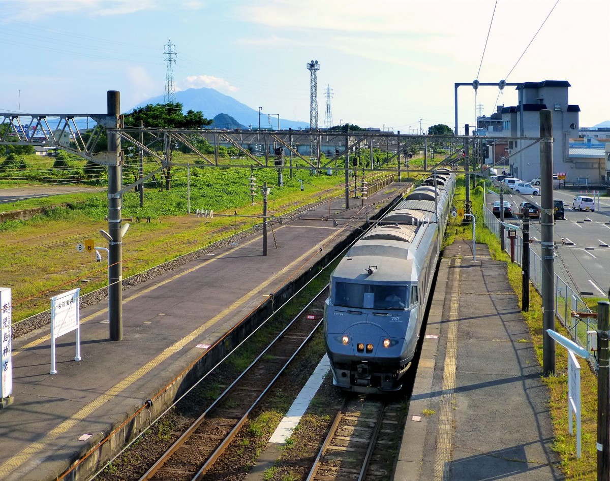 Serie 787 - Intercity-Betrieb im äussersten Süden Japans: Einfahrt des Zuges mit Steuerwagen KUHA 787-6 in Hayato. Im Hintergrund der aktive Vulkan Sakurajima. 3.August 2013. NIPPÔ-HAUPTLINIE 