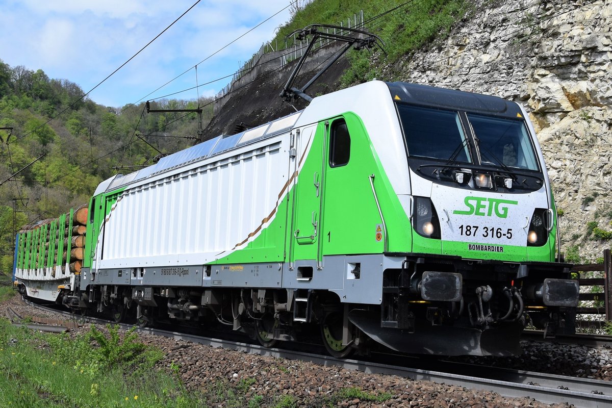 SETG 187 316-5 arbeitet sich mit einem Holzganzzug die Geislinger Steige hoch. Aufgenommen am 28.04.2019, Schublok war die 151 085-8.