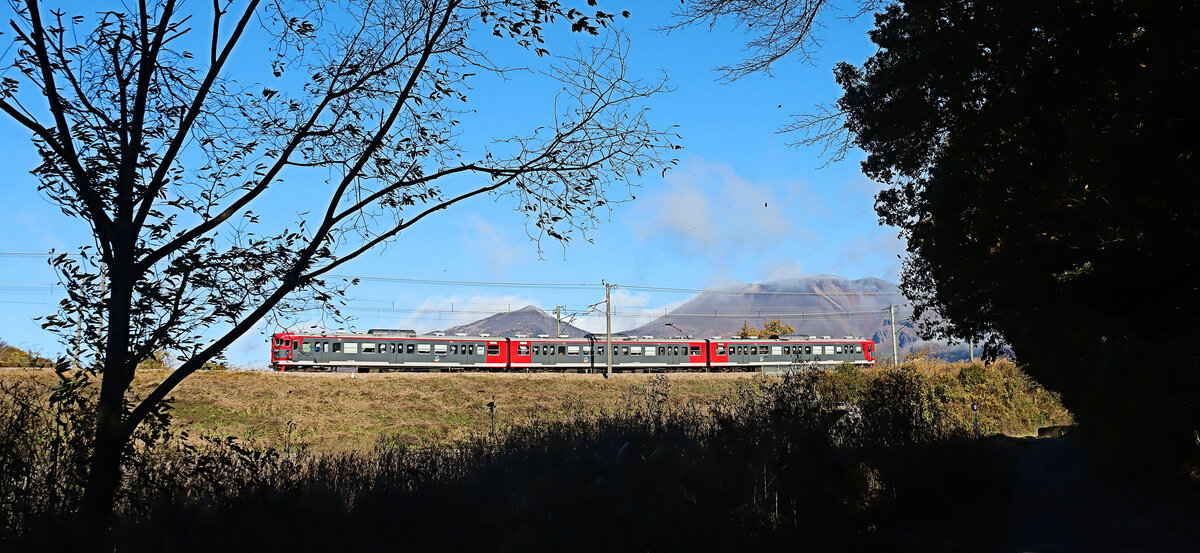 Shinano Bahn: Ein alter Dreiwagenzug Serie 115 am Fusse des aktiven Vulkans Asama im Aufstieg nach Shinano Oiwake, 7.November 2024 