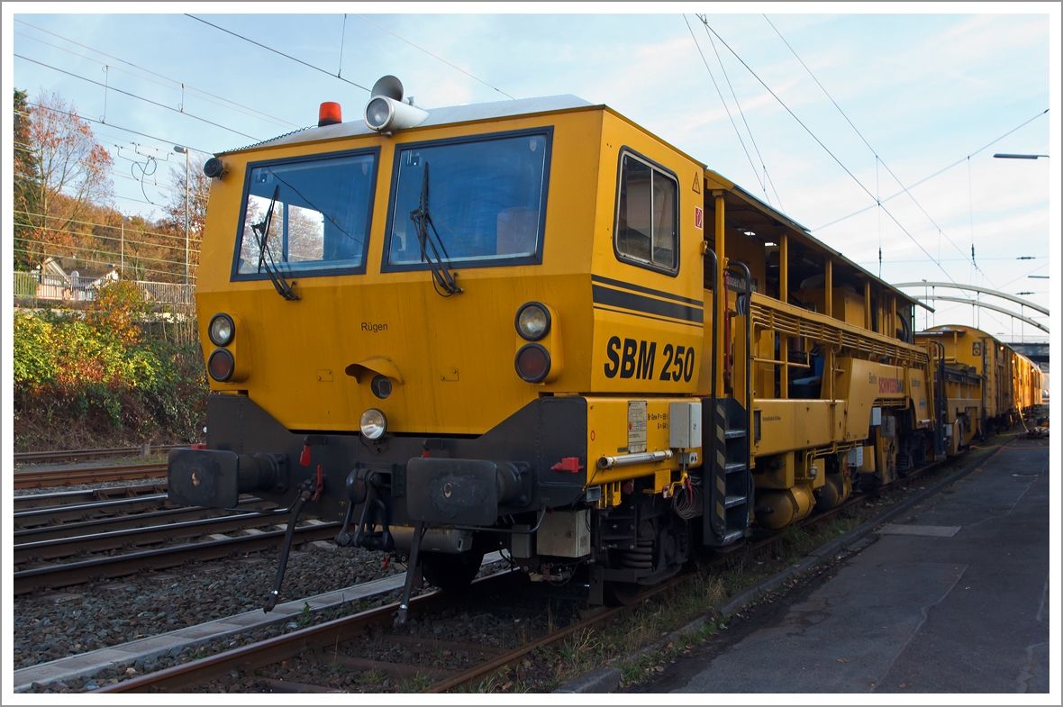 Sieht aus wie eine Stopfmaschine, ist es aber nicht, denn es ist...
Die Plasser & Theurer Schienenbearbeitungsmaschine SBM250 (Schienen-Hobelmaschine) der Schweerbau, Schweres Nebenfahrzeug Nr. 97 33 20 501 17-2, abgestellt am 16.11.2013 in Kreuztal.

Fr die Beseitigung sehr groer Schienenfehler und zur Beseitigung von Spurverengungen ist die Hobelmaschine SBM 250 nach wie vor die technisch beste und gnstigste Lsung.

Die Maschine wurde von Plasser & Theurer  1993 unter der Fabriknummer 48 gebaut.

Technische Daten:
Eigengewicht: 95 t
Zul. Anhngelast: 40 t
Lnge ber Puffer:  28.940 mm  
Hchstgeschwindigkeit: 90 km/h
Zur Mitfahrt zugel. Personen: 6
Zugelassene fr Streckenklasse: C2 und hher