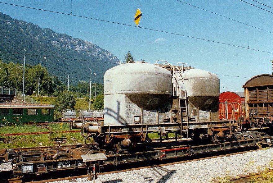Silowagen Ucs der SBB aufgeschemelt auf dem Ua9848 der Brünigbahn in Interlaken-Ost, August 1993 [Staubbehälterwagen, Staubgutwagen]