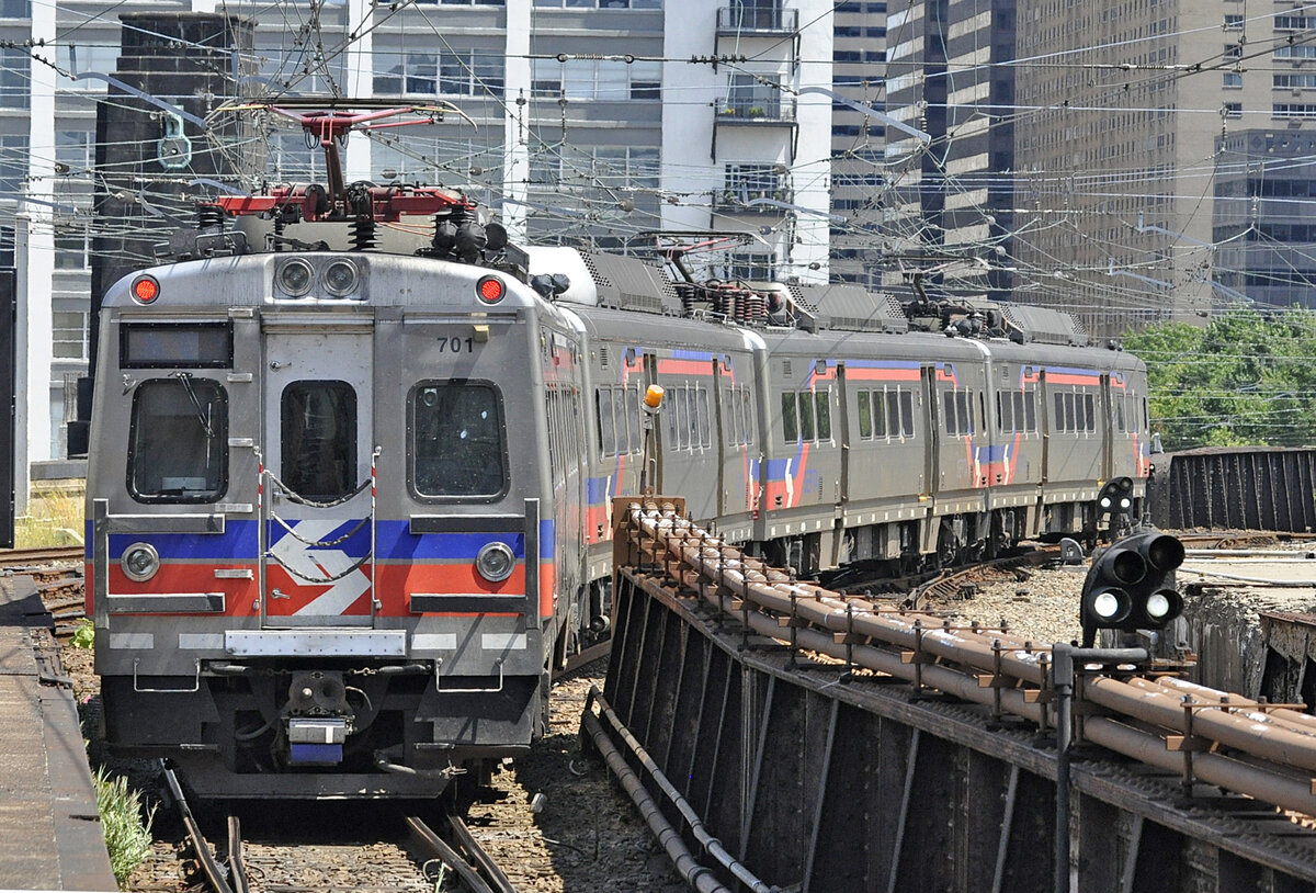 Silverliner V SEPTA 701, Philadelphia 30th Street Station, obere Platform, 10.08.2019. Zug fährt auf die Brücke über den Schuykill River Richtung Zentrum. Auf den ersten Blick sieht man kaum, dass die in Südkorea hergestellten Triebwagen der Silverliner V-Serie (Baujahre 2010-2013) 40 Jahre jünger sind als die der Silverliner IV-Serie (Baujahre 1973-1976).